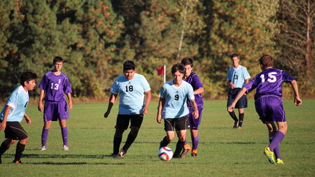 Teenage boys playing soccer in a game between competitive youth sports teams